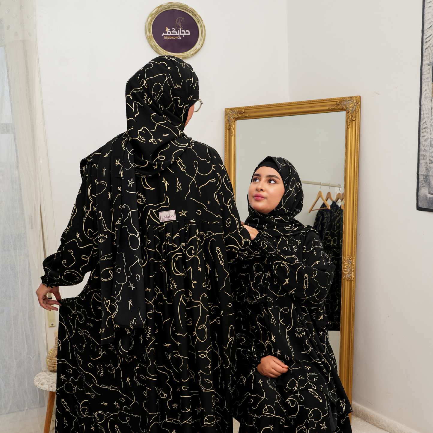 عباية محتشمة بتصميم عملي ولمسة أنثوية راقية  باللون الاسود و الذهبي