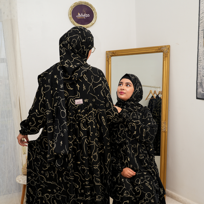 عباية محتشمة بتصميم عملي ولمسة أنثوية راقية  باللون الاسود و الذهبي